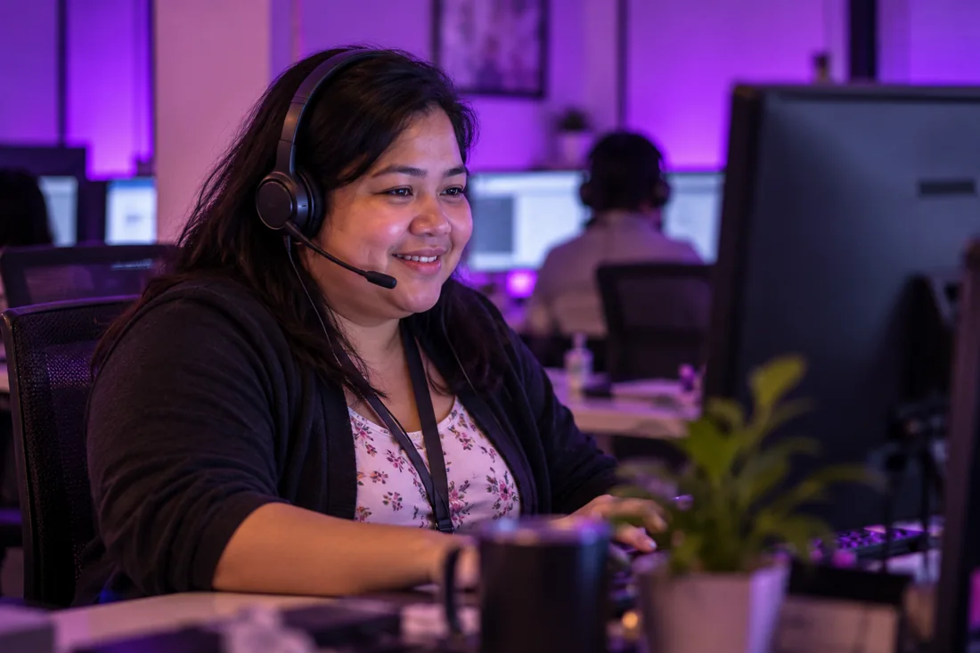 Illustrative image of a call center professional wearing a headset with purple lighting